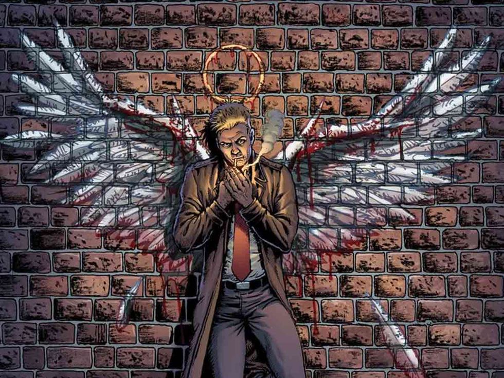 imagen de constantine de un cómic en el que se le ve fumando frente a una pared en la que hay pintadas unas alas de ángel