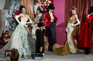 paris, france january 25, 2010 british fashion designer john galliano pictured with models wearing his creations for the luxury fashion brand dior during the winter haute couture show in which he appeared as part of the runway spectacle wearing riding jodhpurs, black boots, a morning coat and tails topped off by a black silk hat and sporting a riding crop with mustard leather gloves photo by derek hudsongetty images