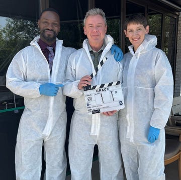 three individuals in protective suits with a clapperboard three individuals in protective suits with a clapperboard