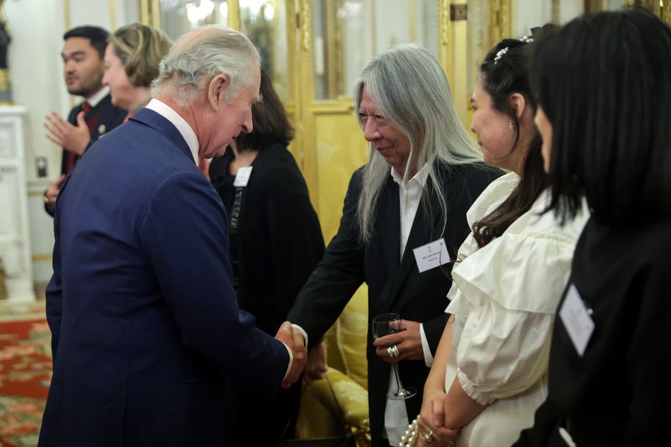 london, england february 01 king charles iii and john rocha shake hands during a reception hosted by the king and the queen consort to celebrate british east and south east asian communities at buckingham palace on february 01, 2023 in london, england the reception is taking place shortly after lunar new year, the holiday began as a time for feasting and to honour household and heavenly deities, as well as ancestors guests include representatives of the armed forces, the arts, media, fashion, business, government, finance, healthcare, faith organisations and charities photo by chris jackson wpa poolgetty images