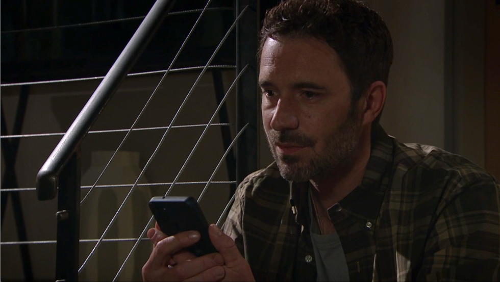 john sugden holds his phone in his hands, emmerdale
