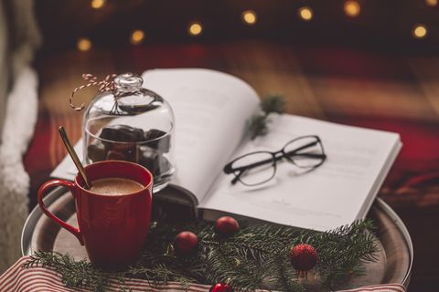hot chocolate and book with glasses in christmas scene