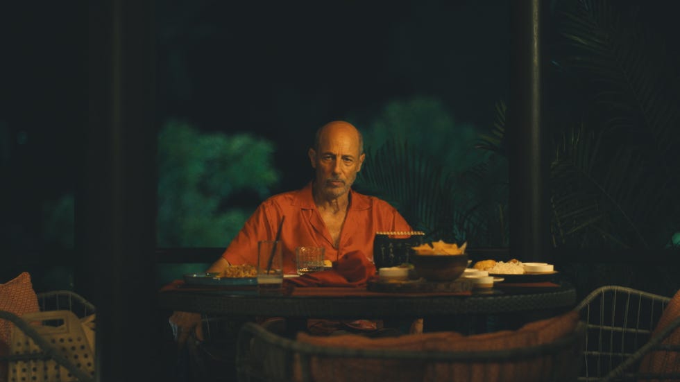 a dining setting at night with a table of food and drinks