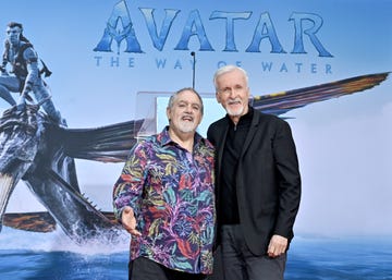 james cameron and jon landau stand smiling at the camera