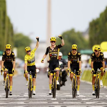 a team of cyclists celebrate as they cross the finish line