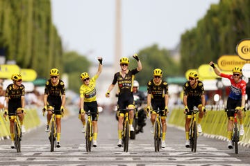 a team of cyclists celebrate as they cross the finish line