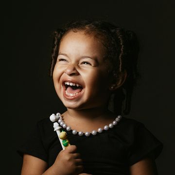 a child laughing and holding a toy