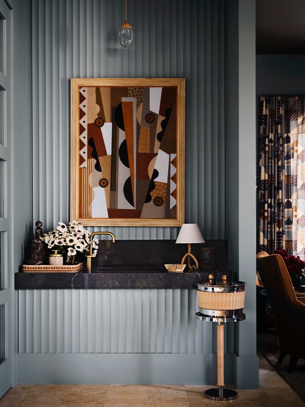 a home bar with a modern painting and black countertops