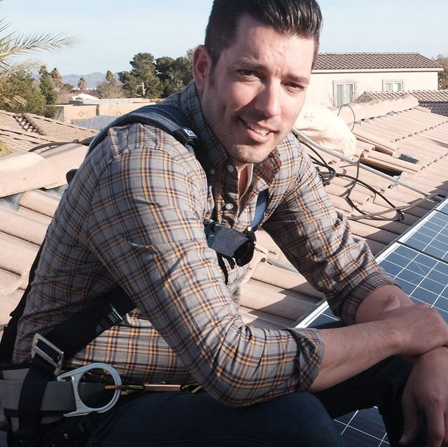 jonathan scott sitting on a roof with solar panels