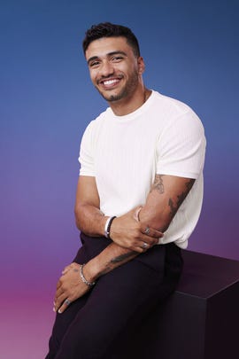 a man with tattoos smiling
