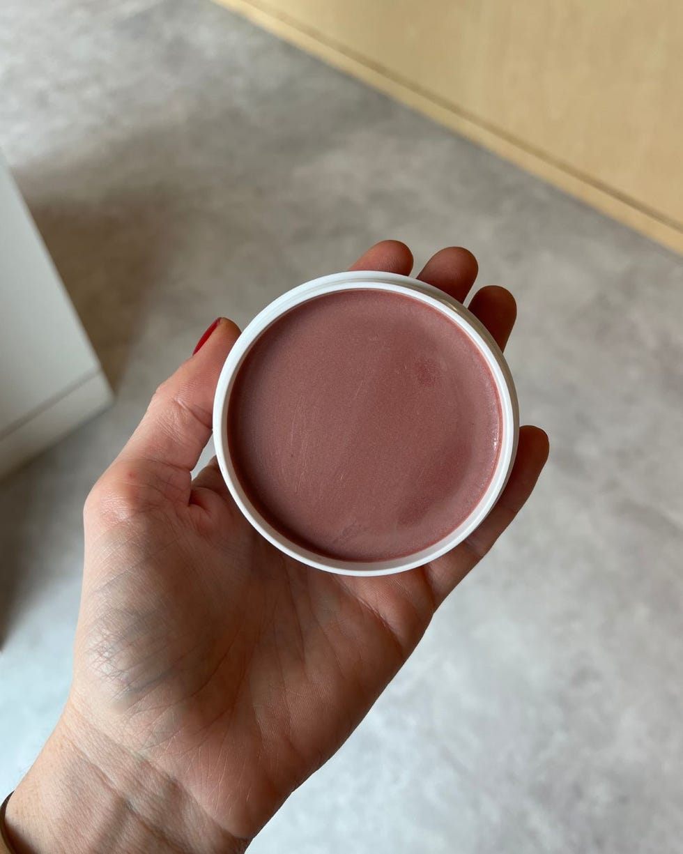 container of cream blush being held by a hand