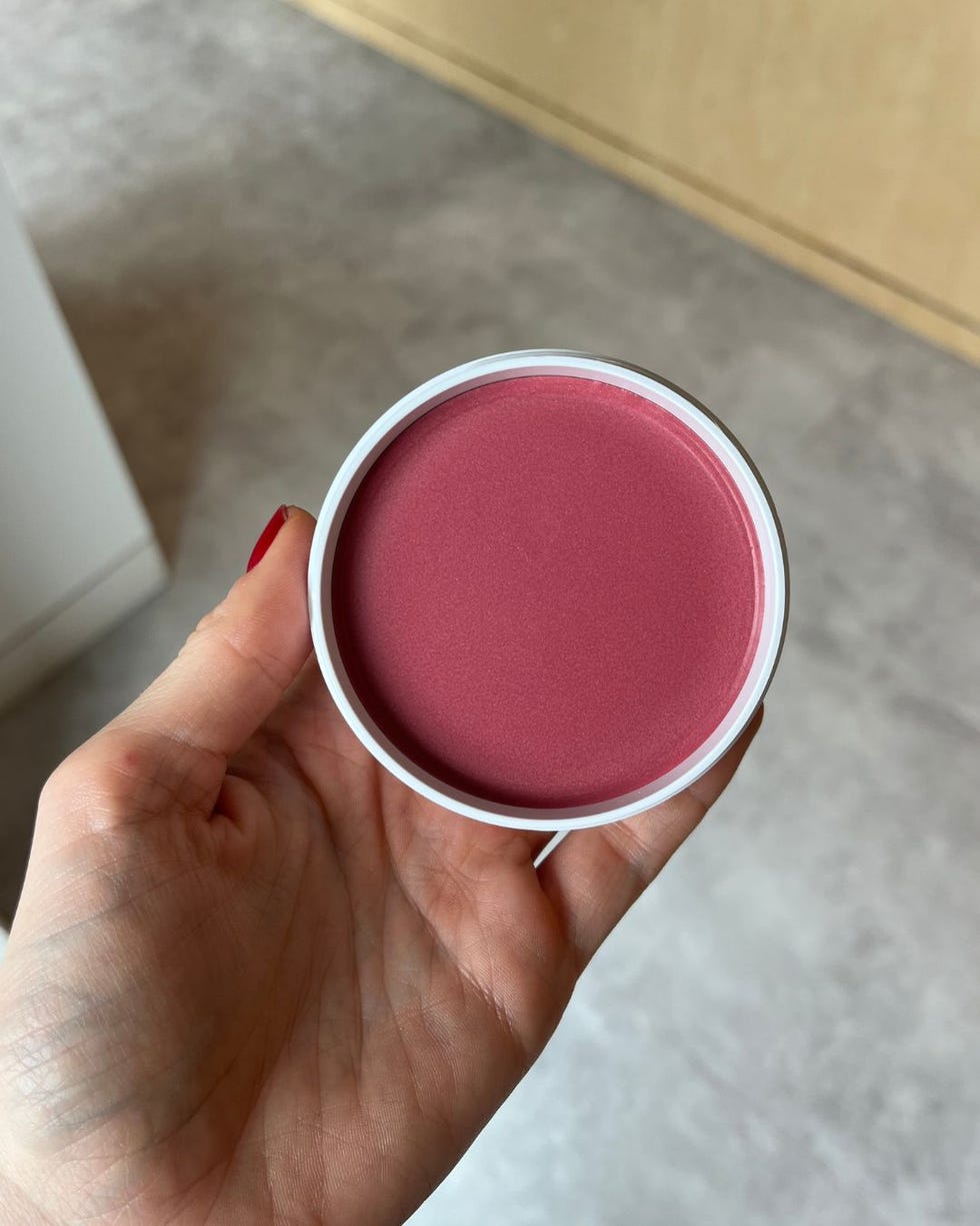 container of cream blush held in a hand