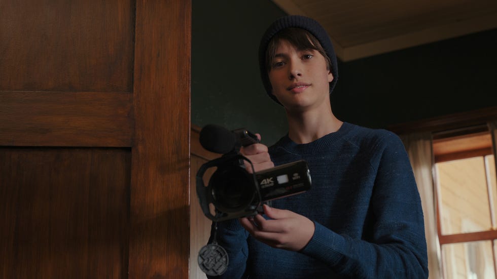 a person holding a camcorder at a door