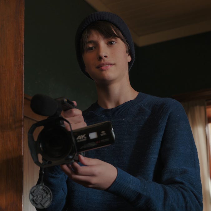 a person holding a camcorder at a door