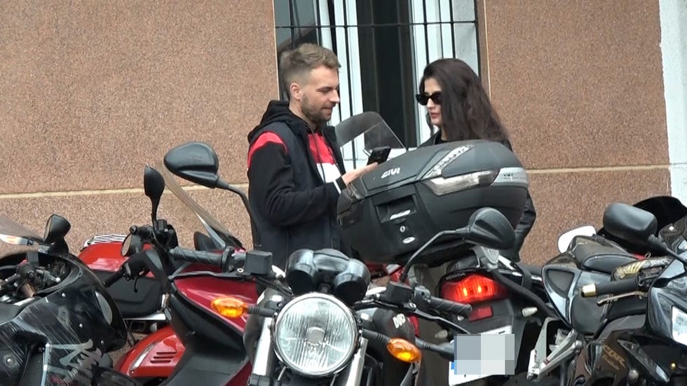 la pareja charla ante las motos estacionadas fuera de una tienda taller de motos en madrid