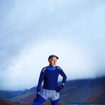 portrait of joss naylor, mbe, standing on top of a mountain and dressed in running clothes