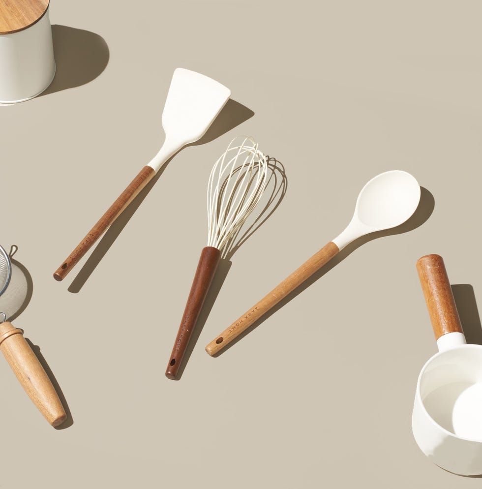 cooking utensils including a spatula whisk and spoon arranged on a surface