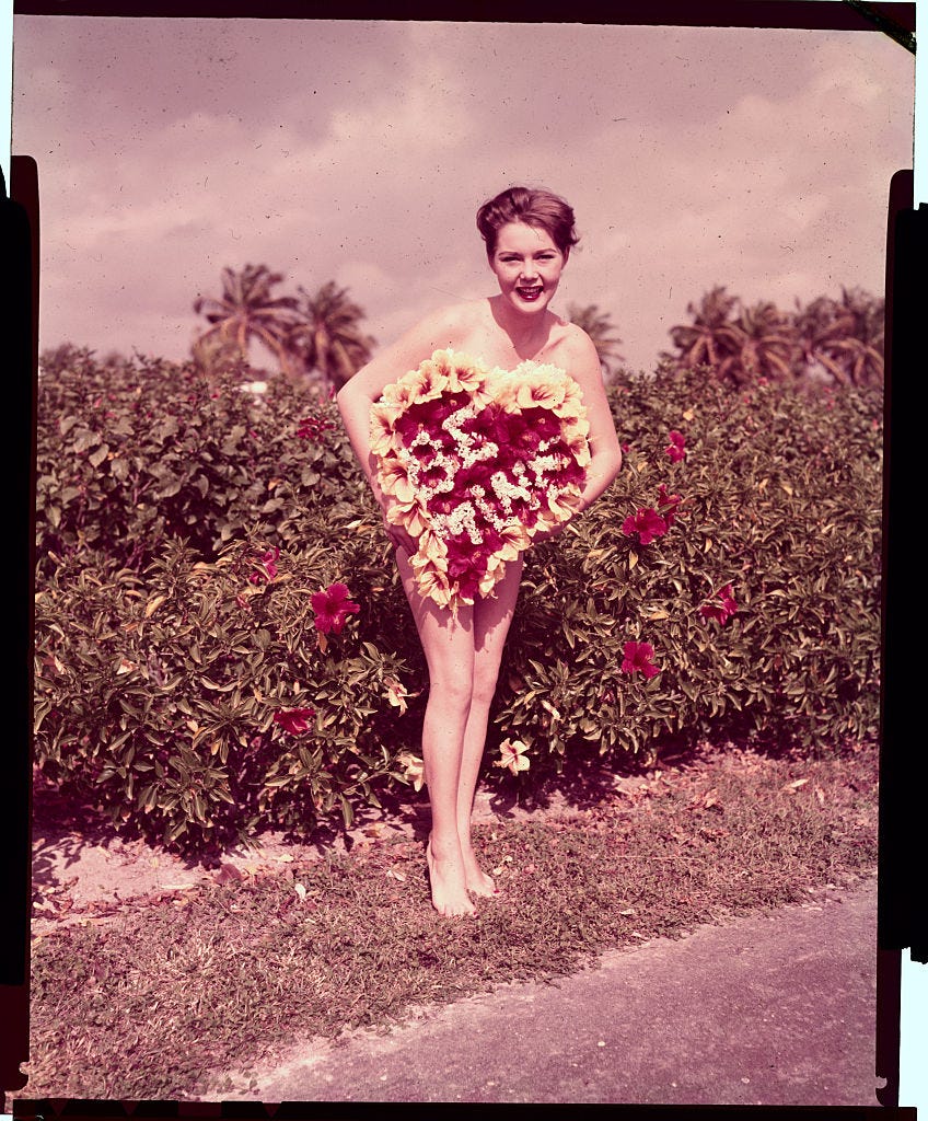 Young Woman Holding Large Valentine Box as Dress Illusion