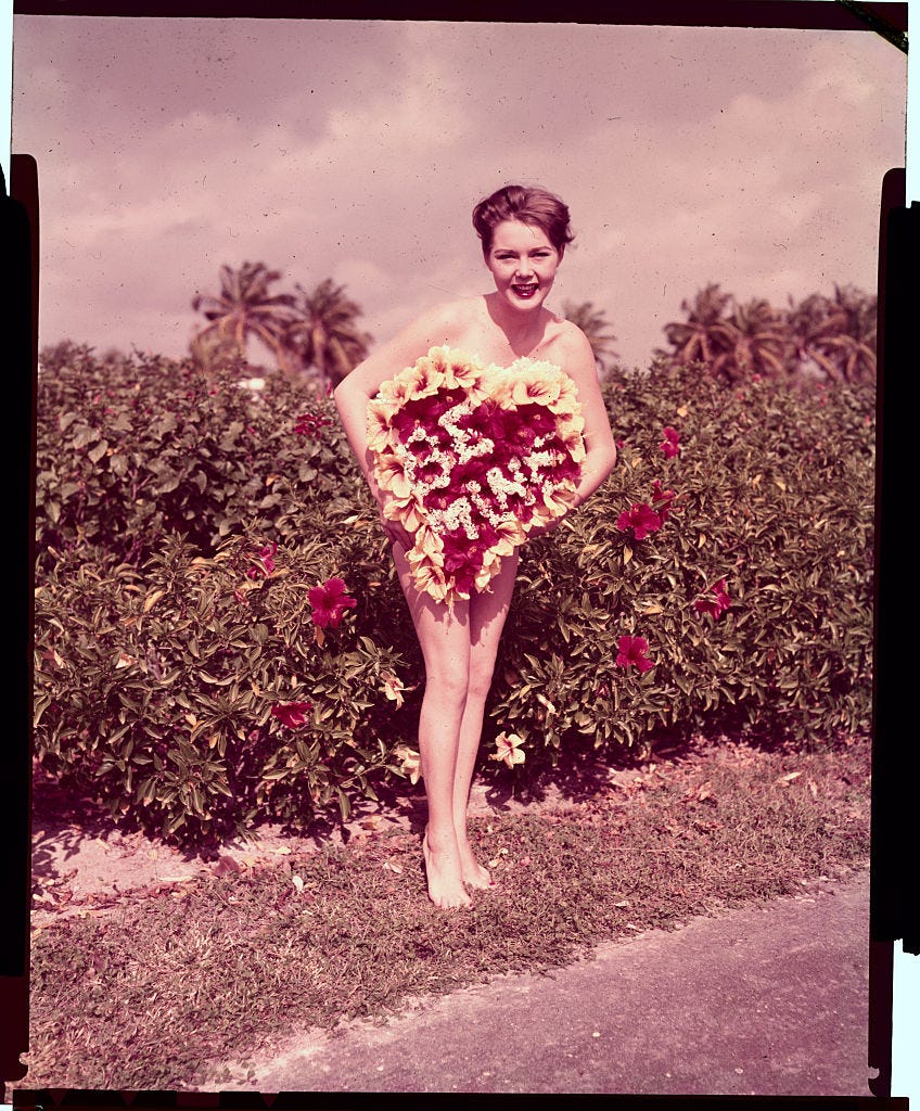 Young Woman Holding Large Valentine Box as Dress Illusion