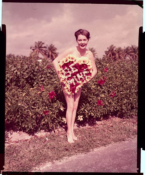 Young Woman Holding Large Valentine Box as Dress Illusion