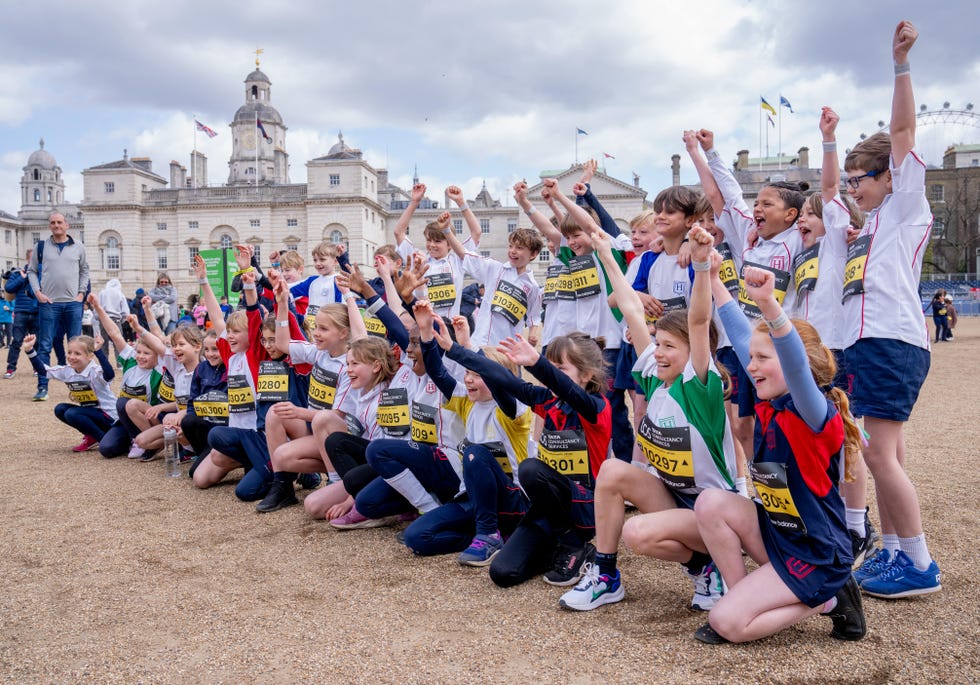 group of schoolchildren cheering together in central london