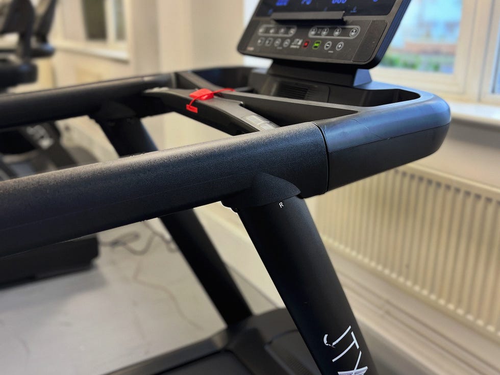 control panel and handlebar of a treadmill in a gym setting