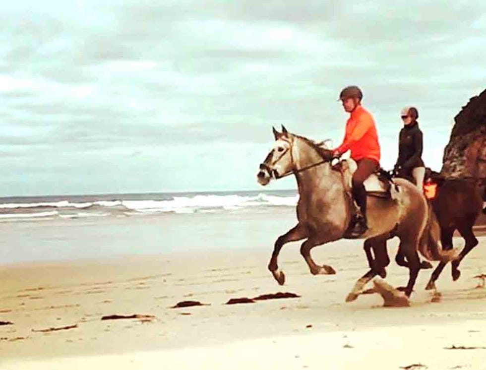 Juan Ramón Lucas y Sandra Ibarra montando a caballo por la playa.