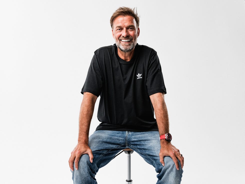 a man seated on a stool wearing casual attire