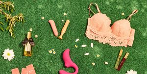 juguetes sexuales sostenibles aceites, consoladores, preservativos, velas, succionador de clítoris en un fondo de césped verde con flores