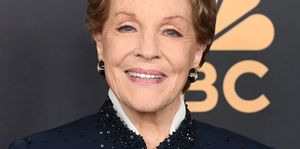 julie andrews smiles at the camera, she wears a navy top with sequins