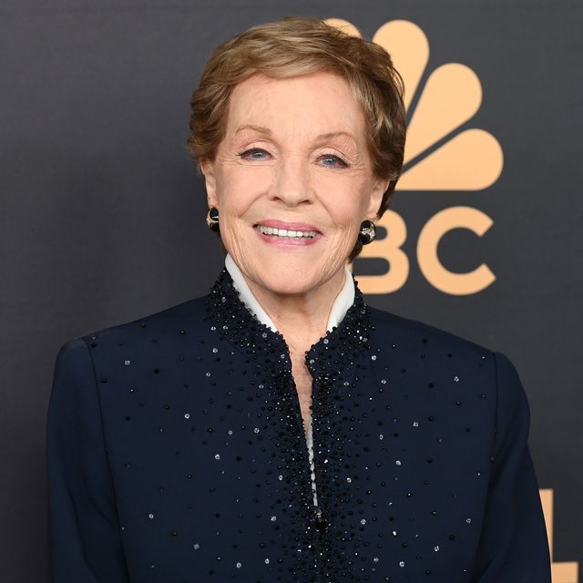 julie andrews smiles at the camera, she wears a navy top with sequins
