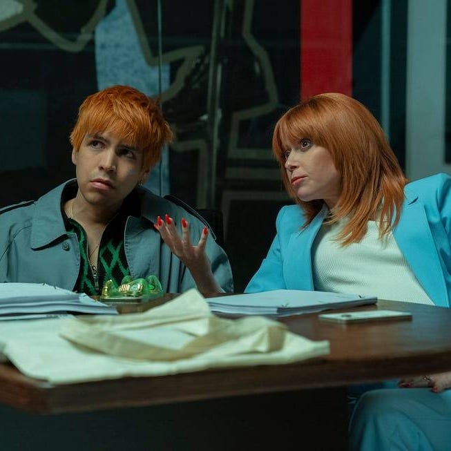 two individuals engaged in discussion at a table with papers