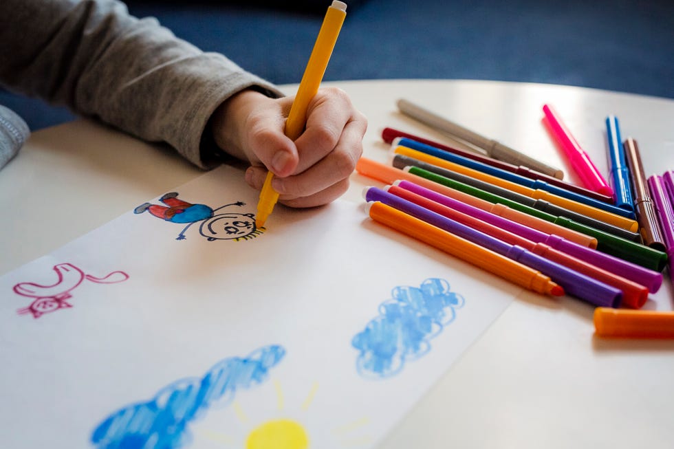 kid drawing with markers with left hand