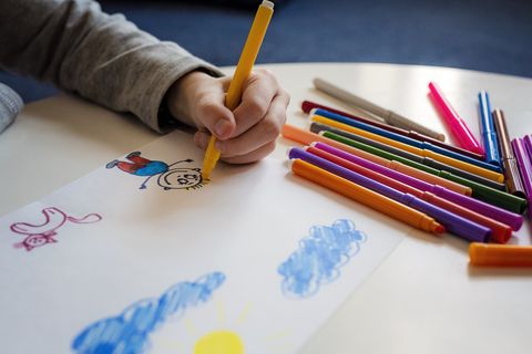 kid drawing with markers with left hand