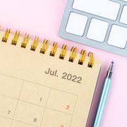 july holidays july 2022 planner on a pink desk with keyboard and pen