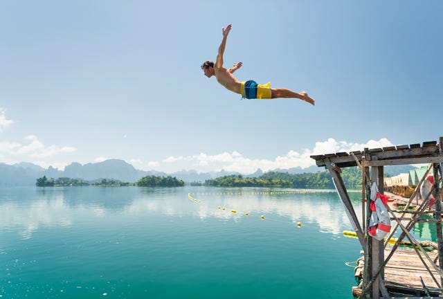 jumping in the clear lake ratchaprapha, khao sok national park, thailand