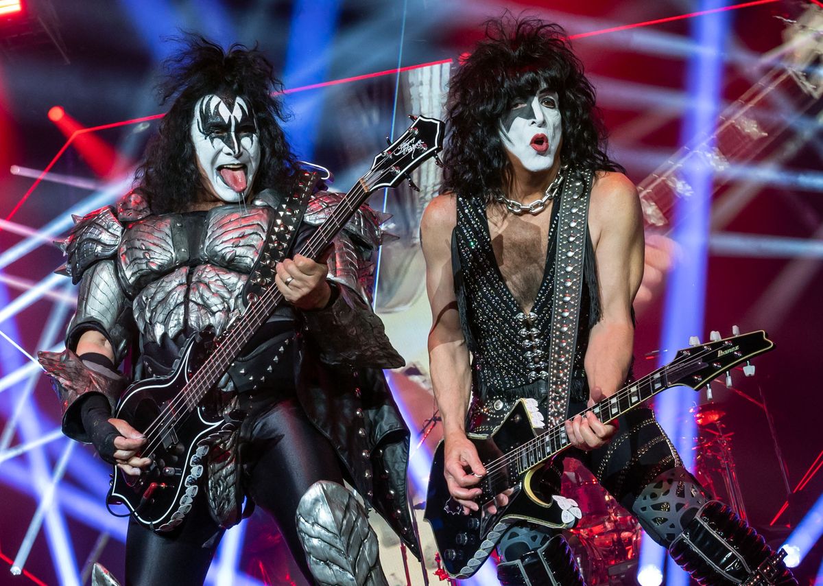 gene simmons and paul stanley of kiss playing guitars at a convert