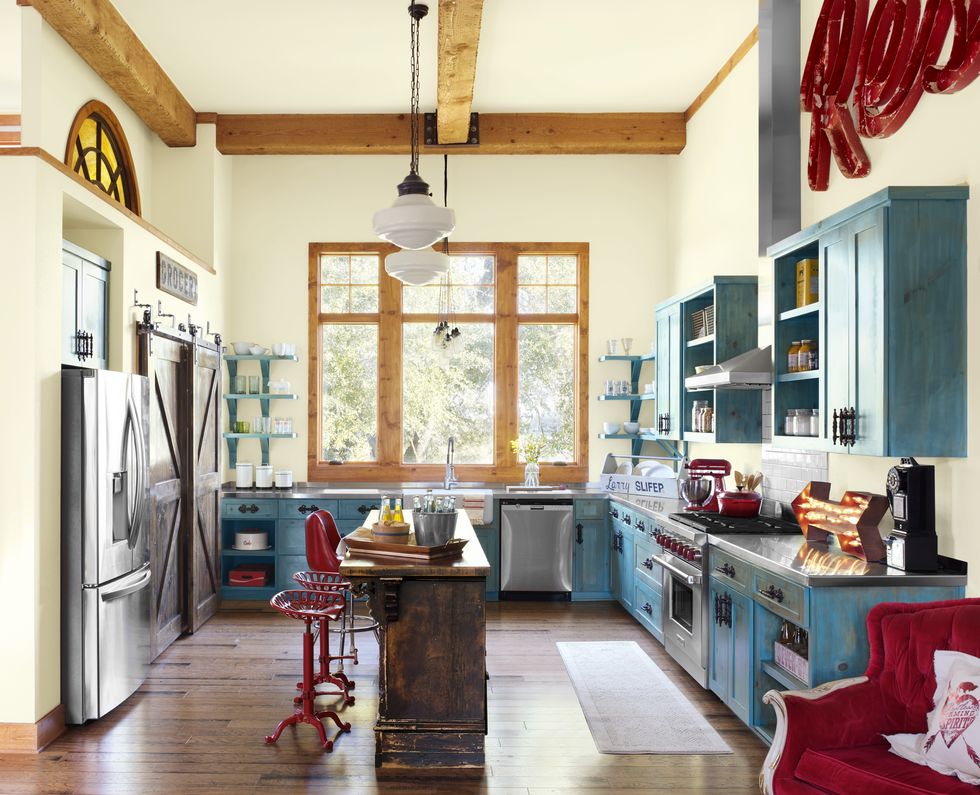 kitchen with turquoise cabinetry, pale yellow walls, and red accents