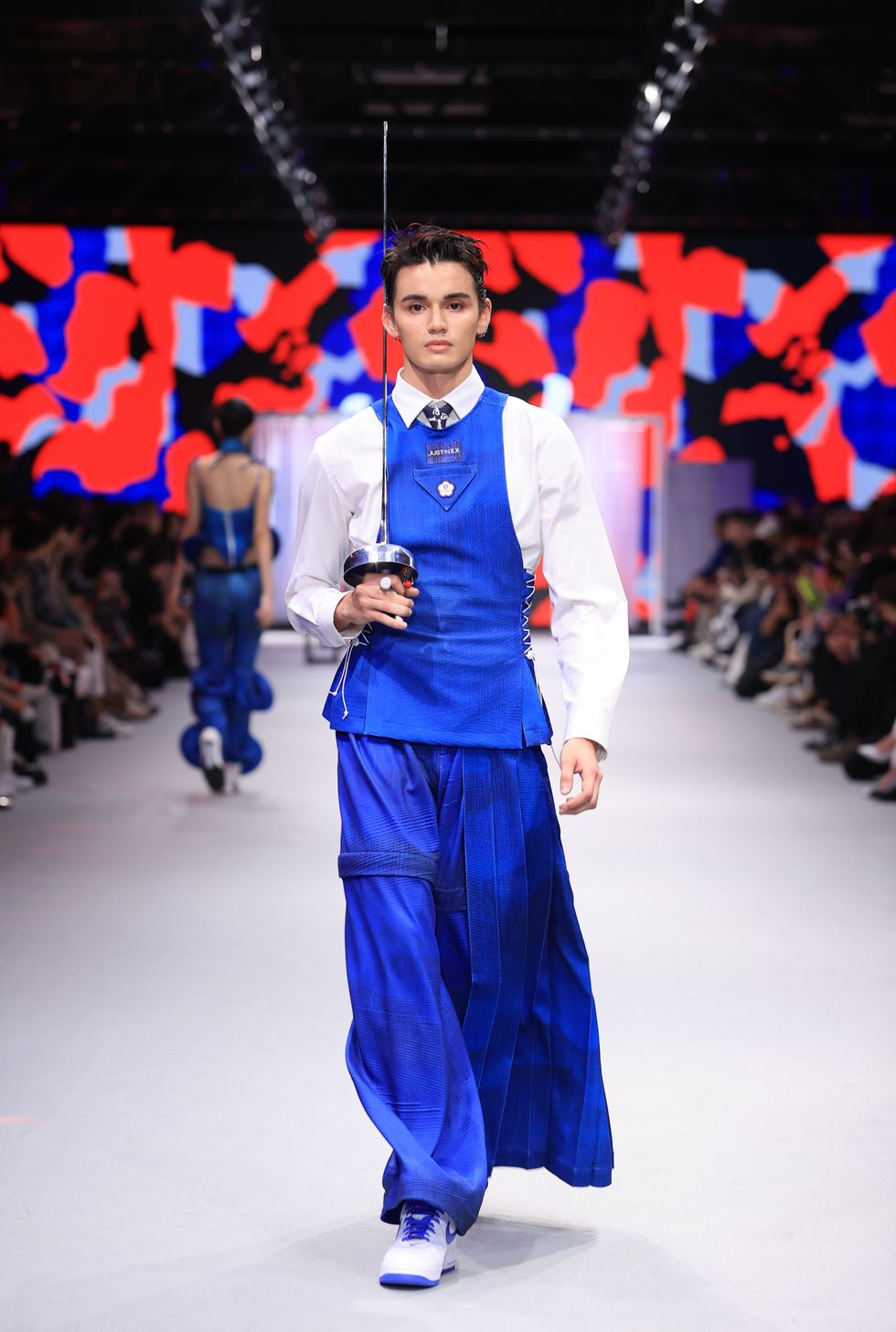a person wearing a blue and white outfit with a camera on a runway
