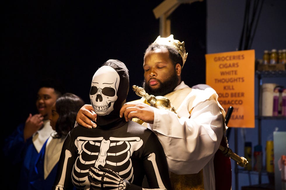 a man holding a saxophone next to a man wearing a mask