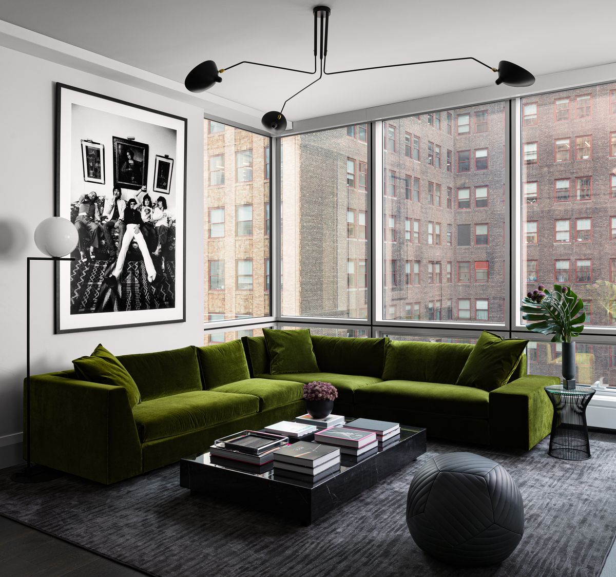 living room, green couch, dark gray rug, black and white wall art