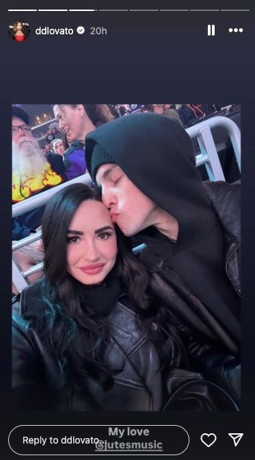 Dos personas disfrutando de un evento vestidas con ropa oscura