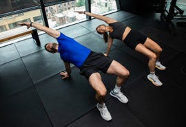 Two individuals performing an exercise in a gym setting