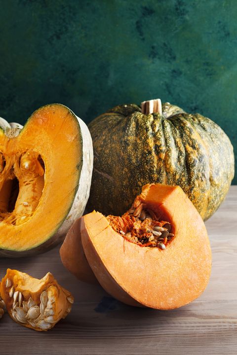 Kabocha Squash whole and cut with green background