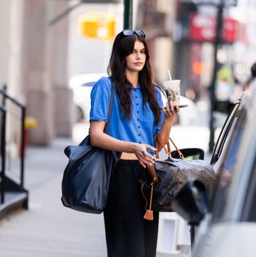 kaia gerber in new york city wearing a blue shirt black joggers and a celine bag