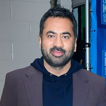 actor kal penn holds a copy of his autobiography and smiles at the camera in november 2021