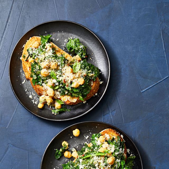 kale and chickpea toasts on black plates