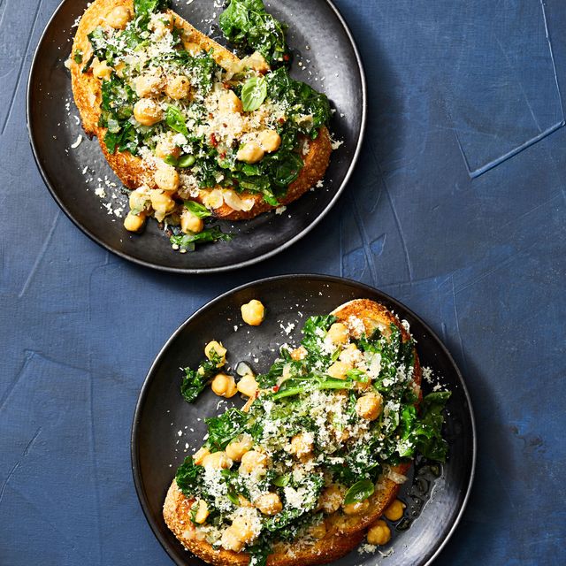 kale and chickpea toasts on black plates