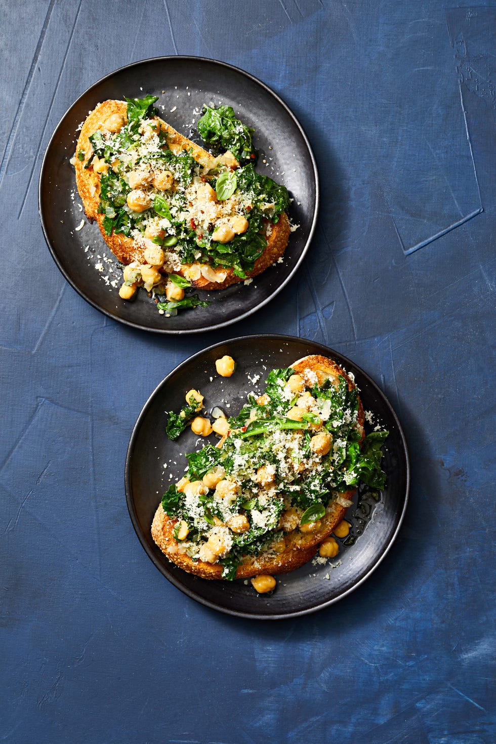 kale and chickpea toasts on a black plate