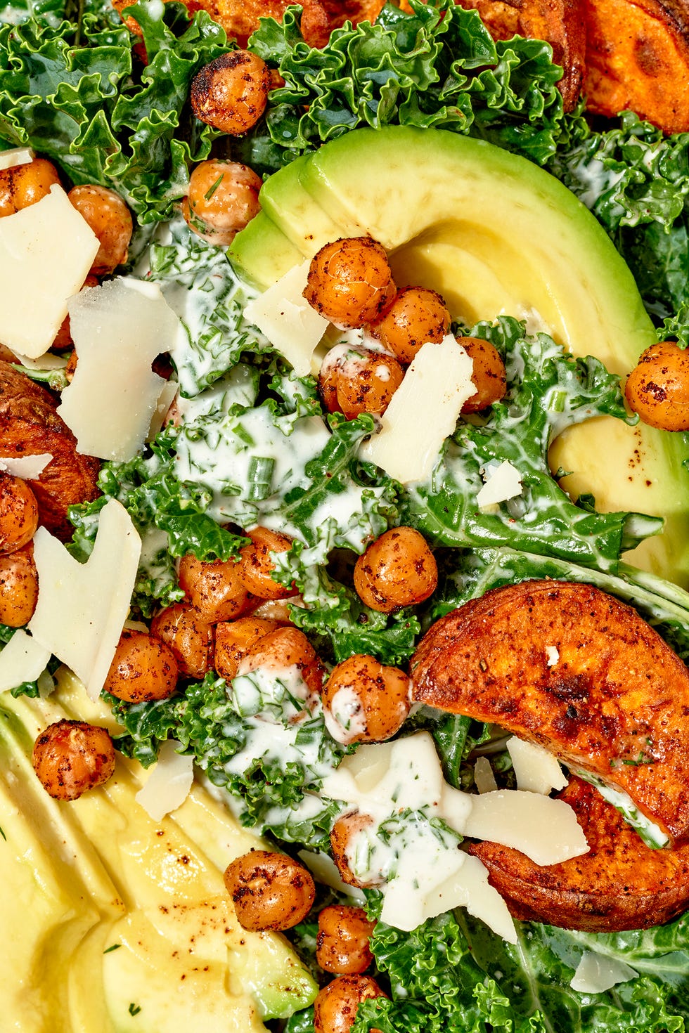 closeup of vegan kale salad with crunchy chickpeas, sweet potatoes, and avocado